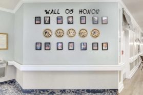 A line of photos of retired staff on the walls of the senior living community