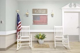 Two chairs in the corner of the room with the US flag